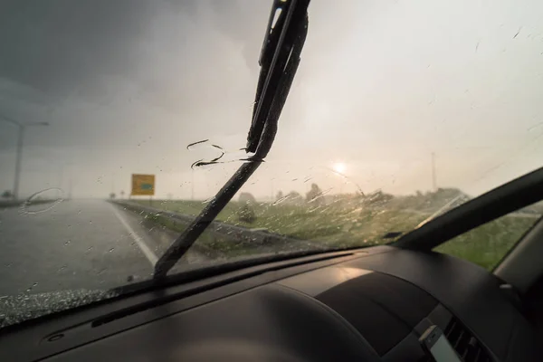 Windshield wipers from inside of car in the rainy day