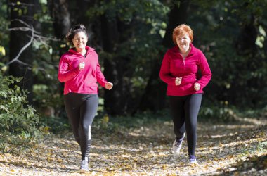 Anne ve kız spor kıyafetleri giyip dağda ormanda koşuyorlar.