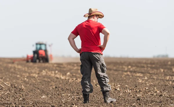 Agricultor Examinando Campo Trigo Plantado Mientras Tractor Está Arando —  Fotos de Stock