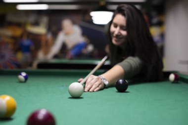 Çok gülümseyen kız bilardo oynarken 