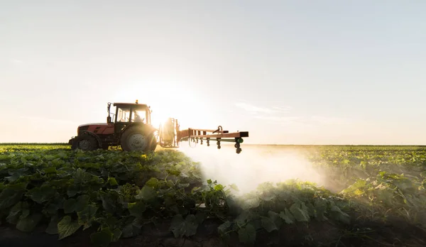 用喷雾器在拖拉机上做肥料的农民 — 图库照片