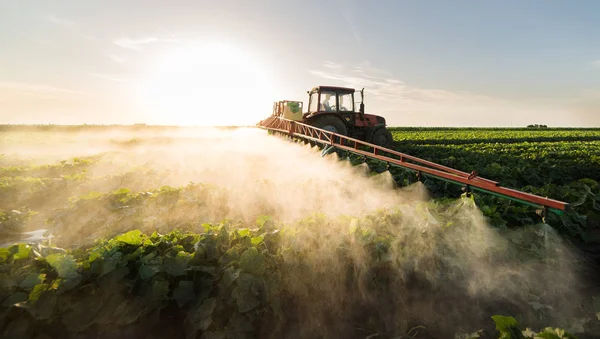 用喷雾器在拖拉机上做肥料的农民 — 图库照片