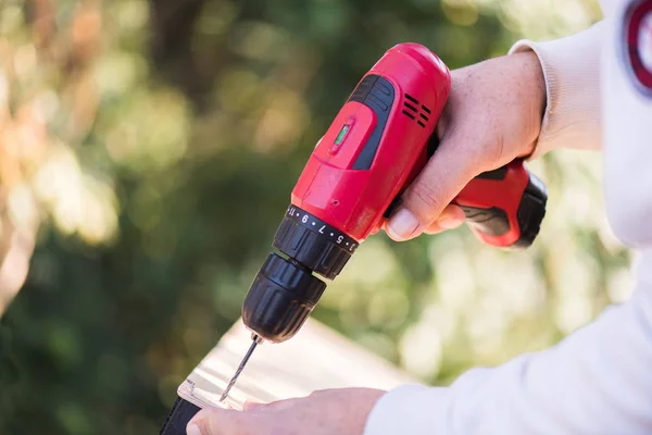 Tischler bohrt mit Elektrobohrer ein Loch — Stockfoto