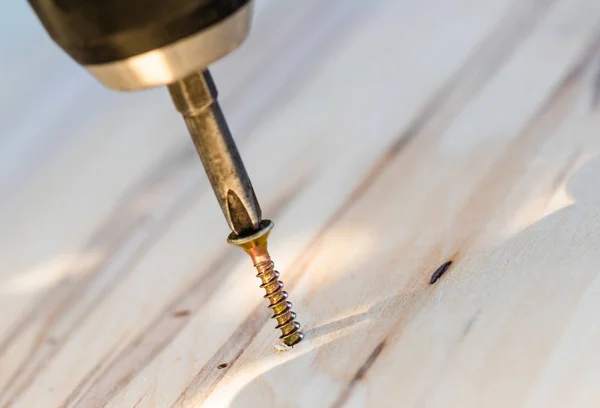 Carpenter drills a hole with an electrical drill — Stock Photo, Image