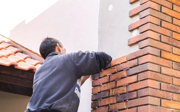 Trabajador poniendo ladrillos rojos en la pared de la casa —  Fotos de Stock