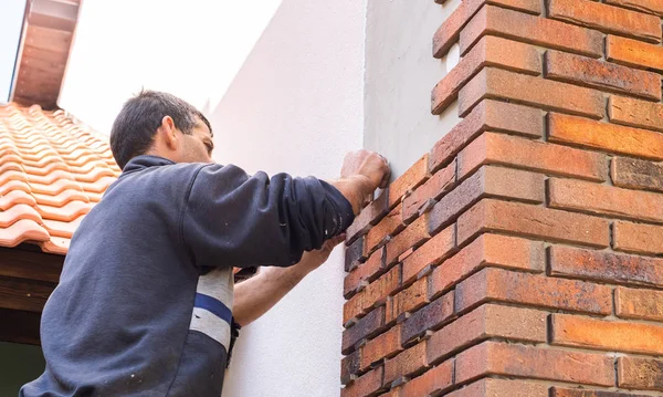 Trabalhador colocando tijolos vermelhos na parede da casa — Fotografia de Stock