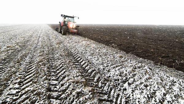 Tracteur labourant un champ — Photo