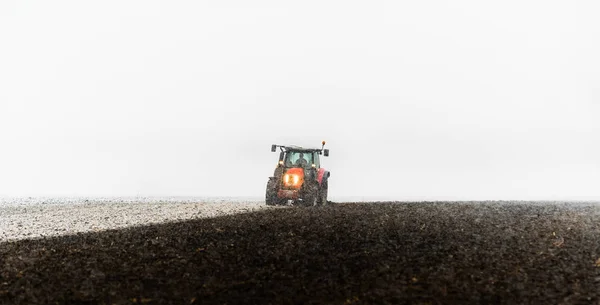 Tracteur labourant un champ — Photo