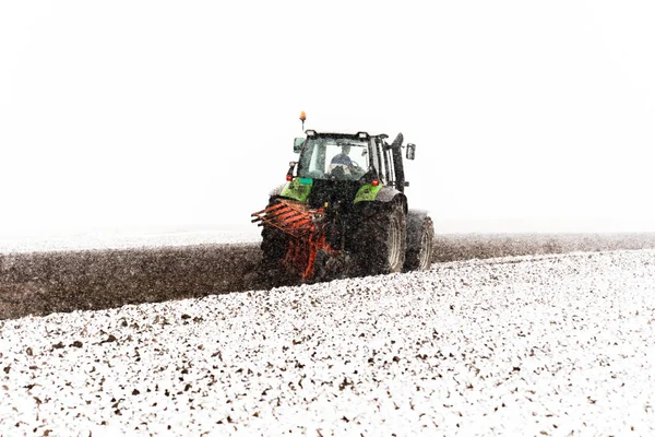 Trekker ploegt een veld — Stockfoto