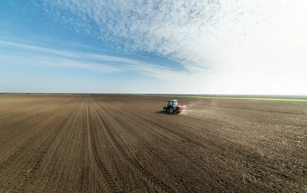 Traktor na poli rozmetává umělá hnojiva — Stock fotografie