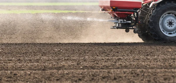 Trator espalhando fertilizantes artificiais no campo — Fotografia de Stock