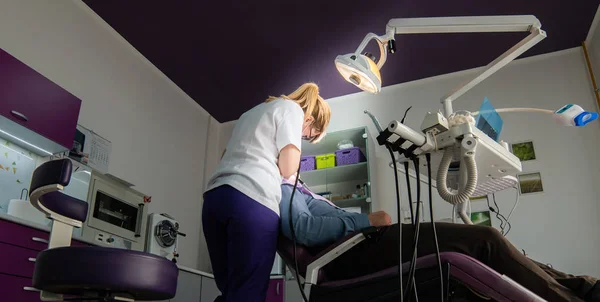 Dentista femenina con herramientas dentales revisando los dientes del paciente — Foto de Stock