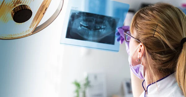 Dentista femenina sosteniendo imagen de rayos X — Foto de Stock