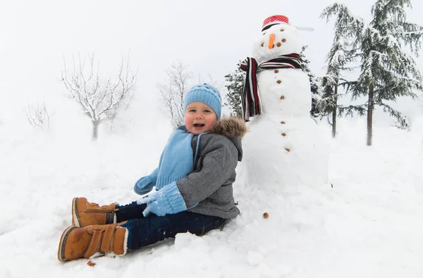 Usměvavý chlapeček hraje ve sněhu — Stock fotografie