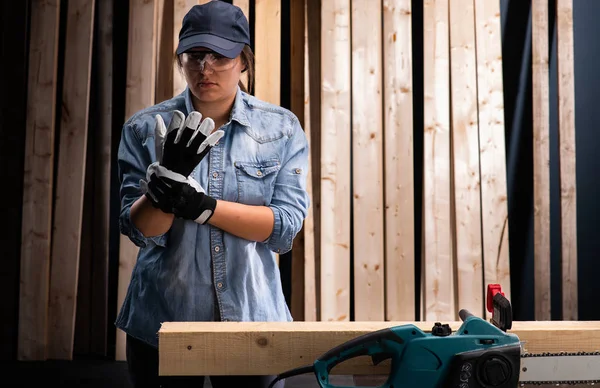 Junge Frau mit moderner Elektrosäge in der Werkstatt — Stockfoto