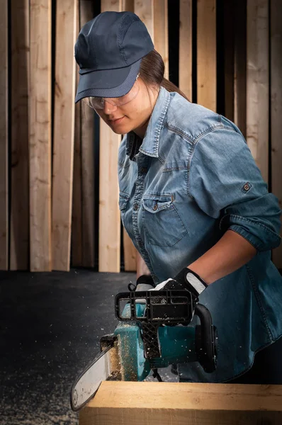 Mujer joven usando sierra eléctrica moderna en el taller —  Fotos de Stock