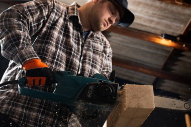 Atölyede modern elektrik dairesel testere kullanan adam