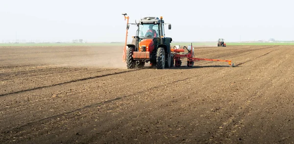 Agricultor com culturas de sementeira de tractor no campo agrícola — Fotografia de Stock