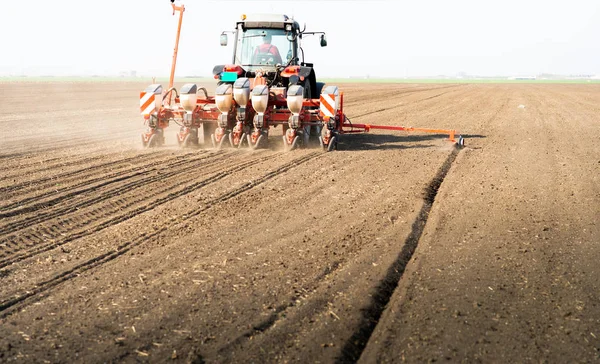 Farmer with tractor seeding sowing crops at agricultural field — Stock Photo, Image