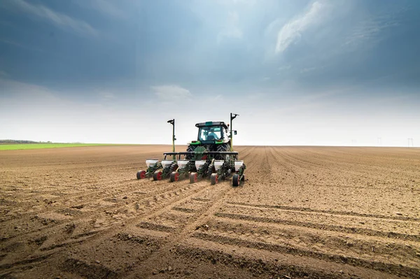 Landwirt mit Traktor beim Säen von Feldfrüchten — Stockfoto