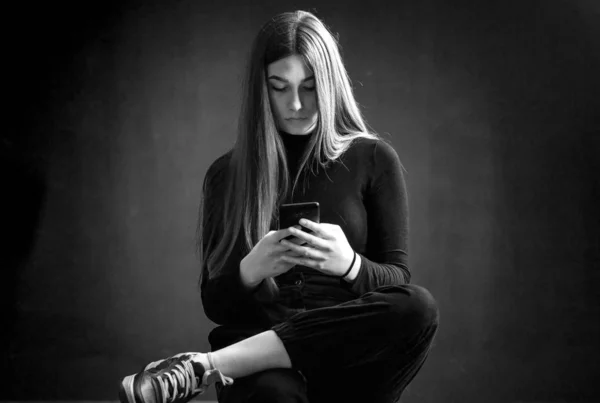 Beautiful young girl using her mobile phone — Stock Photo, Image