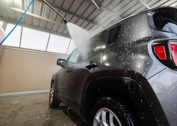 Ручна мийка автомобіля з водою під тиском — стокове фото