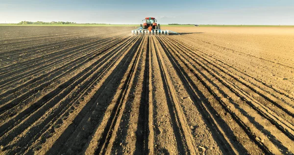 Agricultor com culturas de soja de sementeira de trator no campo agrícola — Fotografia de Stock