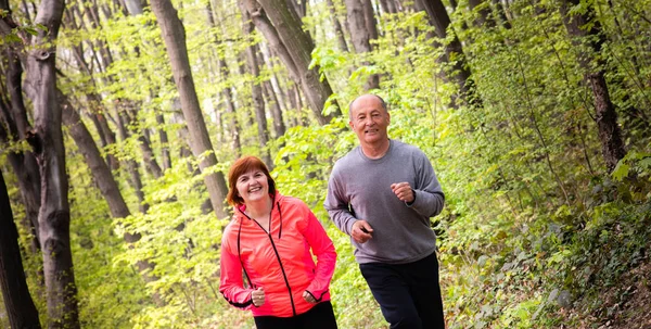 Mann und Frau tragen Sportbekleidung und laufen im Wald — Stockfoto