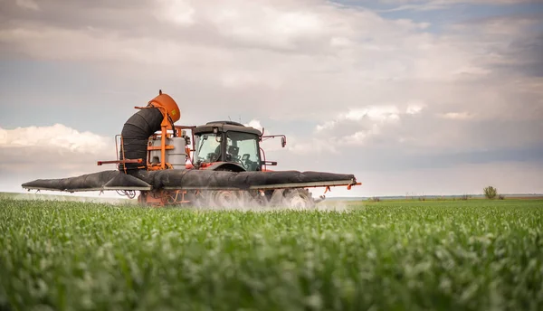 Tractor rociando pesticidas en el campo de trigo — Foto de Stock