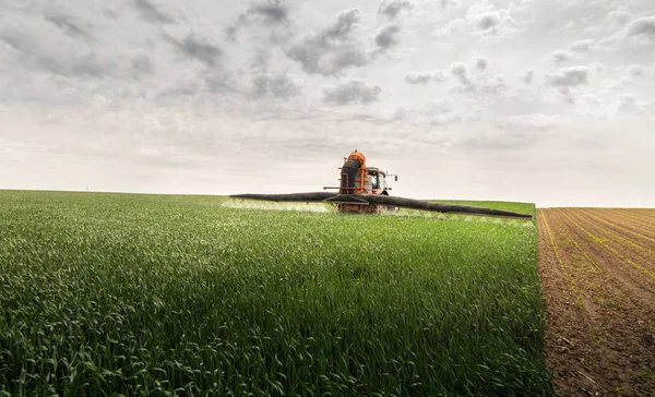 Traktor versprüht Pestizide auf Weizenfeld — Stockfoto