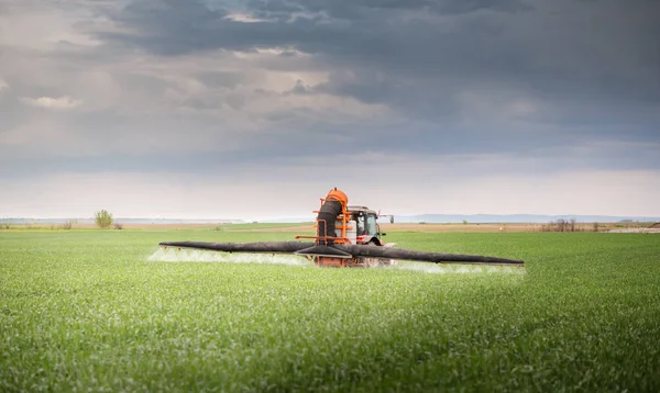 Tractor spraying pesticides at  wheat  field — Stock Photo, Image