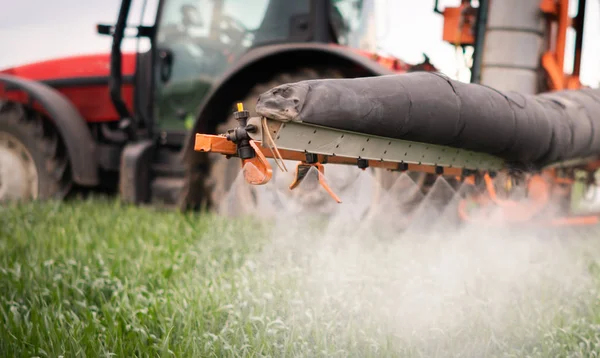 Tractor spraying pesticides at  wheat  field — Stock Photo, Image