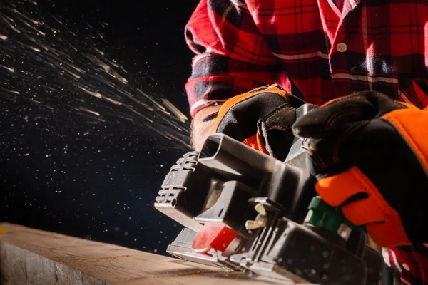 Timmerman werkt met elektrische schaafmachine — Stockfoto