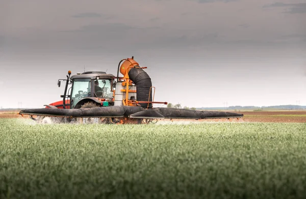 Traktor postřiku pšeničné pole — Stock fotografie