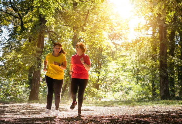 Twee middelbare leeftijd vrouwen running — Stockfoto