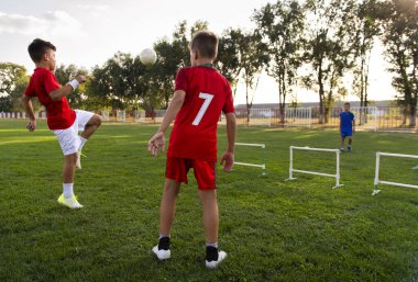 Çocuklar futbol sahasında birbirlerine pas atıyorlar.. 