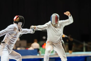 Eskrim yarışmasında dövüş. Profesyonel spor sahasında iki eskrim sporcusu kavga ediyor