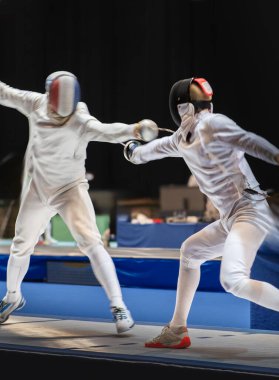 Eskrim yarışmasında dövüş. Profesyonel spor sahasında iki eskrim sporcusu kavga ediyor