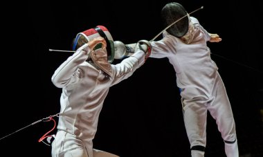 Eskrim yarışmasında dövüş. Profesyonel spor sahasında iki eskrim sporcusu kavga ediyor