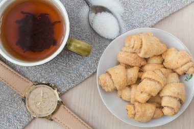 Bir çay bardağı ile ekmek ve ahşap saat ve tuval arka plan. Sabah yükleme