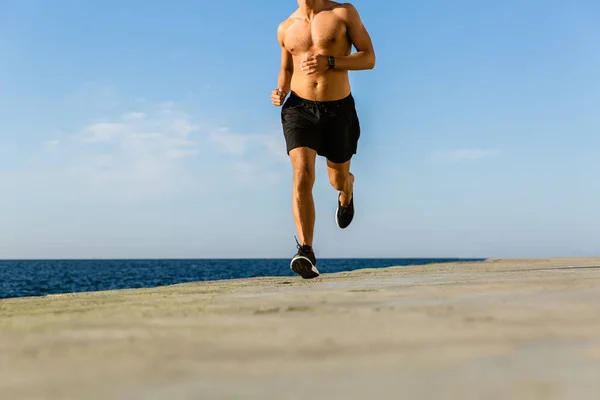 裸运动员在海边慢跑的裁剪镜头 — 图库照片