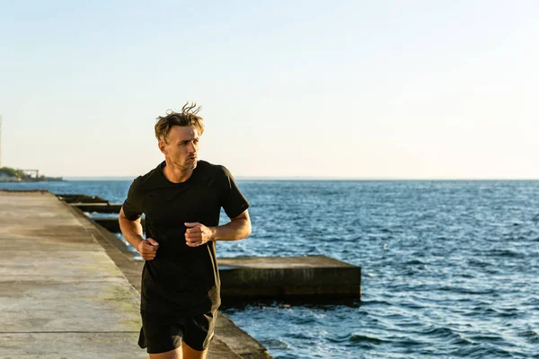 Athletic Adult Man Black Sportswear Jogging Seashore Morning — Stock Photo, Image