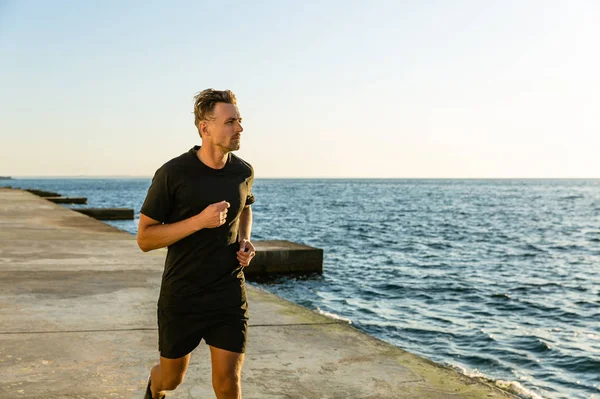 Adulto desportista jogging no litoral de manhã — Fotografia de Stock