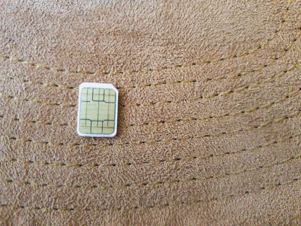 one micro sim card on a wooden surface background