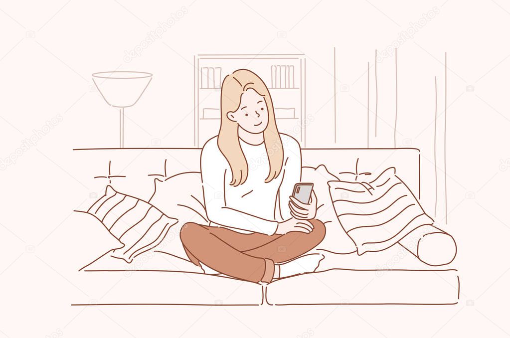 Young smiling attractive woman or girl using a smartphone writes or speaks at home. Concept of communication, comfort, smart.