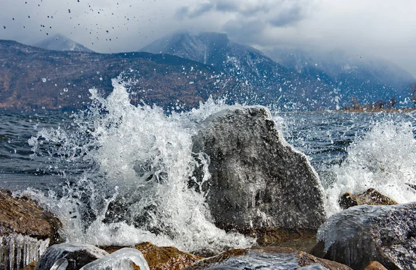 The beating waves on the rocks. Russia. mountain Altai. Early spring in the South of lake Teletskoye.