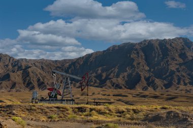 Tacikistan. Mekanik itiş çubuğu pompası (rocker), Isfara kenti yakınlarındaki Pamir dağlarındaki bir kuyudan petrol pompalıyor