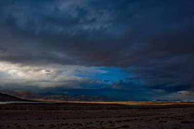 Tacikistan. Bulunkul Gölü 'nün yüksek rakımlı bölgesinde Pamir karayolu üzerinde dramatik bir akşam gökyüzü.