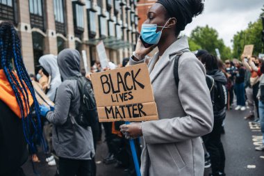 Londra / İngiltere - 06 / 06 / 2020: Siyahi Yaşamı Önemlidir protestosu koronavirüs salgını sırasında. Siyah pankartlı kadın.