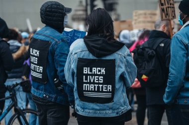 Londra / İngiltere - 06 / 06 / 2020: Siyahi Yaşamı Önemlidir protestosu koronavirüs salgını sırasında. Protestocular üzerinde BLM işareti olan ceketler giyiyorlar